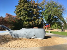 Am Eingang des Wasserspielplatzes am Tannenhofweg steht ein etwa fünf Meter langer Pottwal als Wasserspielskulptur. Foto: Landeshauptstadt Düsseldorf/Gartenamt