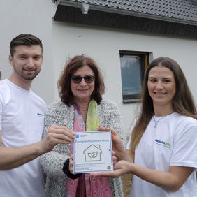 Umweltdezernentin Helga Stulgies (Mitte) überreicht den Hauseigentümern Jennifer Breising und Rafael Wybranietz die Plakette "Energieeffizientes Haus", Foto: Wilfried Meyer
