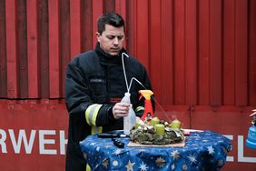Feuerwehrsprecher Christopher Schuster erklärt, wie man einen Adventsbrand im Anfangsstadium bekämpfen kann. Foto: Michael Gstettenbauer