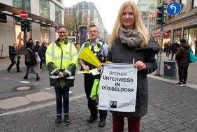 "Sicher durch die dunkle Jahreszeit": Sonja Zimmer, Verkehrswacht, Michael Knapke, Polizei, und Antonia Schnelle, Stadt Düsseldorf, (v.l.) zeigen wie es geht - mit heller und reflektierender Kleidung und Accessoires. Foto: Uwe Schaffmeister