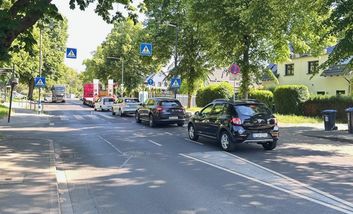 Foto von weiterem Teilabschnitt der Gubener Straße mit parkenden Autos am Fahrbahnrand.