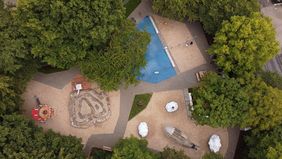 Umrahmt von Schatten spendendem Grün liegt der Wasserspielplatz an der Peter-Behrens-Straße; Foto: Young