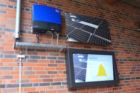 An der Außenwand des Technikgebäudes sind der Wechselrichter sowie eine Anzeigentafel mit aktuellen Anlagendaten installiert. Foto: Ingo Lammert