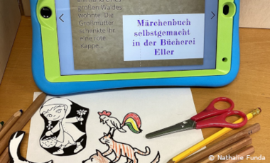 Foto von Tablet-PC und Papier mit Zeichnungen von Märchenfiguren mit dem Text: Märchenbuch selbstgemacht in der Bücherei Eller