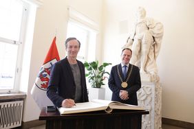 Im Rahmen seines Besuches trug sich Volker Bertelmann (l.) in das Goldene Buch der Landeshauptstadt ein
