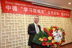 OBThomas Geisel an einem Rednerpult, hinter ihm ein Banner "Sino-German Learning City Stakeholder Forum: Urban Regeneration"