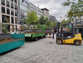 Foto zeigt einen Gabelstapler, der die neuen Pflanzkübel von einem LKW ablädt