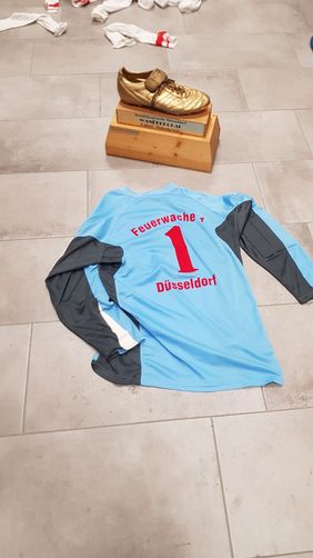 Der Pokal mit dem Siegertrikot.