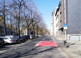 Der Beginn der Radverkehrsanlage auf der rechten Spur der Prinz-Georg-Straße wird zusätzlich zum blauen Radwegschild durch breite und rot eingefärbte Flächen gekennzeichnet. Foto: Amt für Verkehrsmanagment