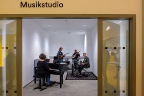 Das neue Musikstudio in der Zentralbibliothek mit einem hybriden Flügel, einer E-Gitarre, einem E-Bass und einem E-Drum-Set