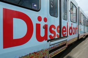 Das Kampagnenmotto "Mach's! Für dich und Düsseldorf" schmückt eine Rheinbahn und andere Werbeträger wie Plakate und Klimafibel. Foto: David Young