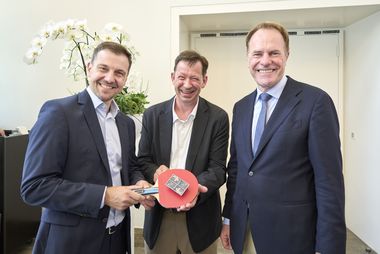 OB Dr. Stephan Keller (r.) und Stadtdirektor Burkhard Hintzsche überreichten Timo Boll (l.) eine Miniaturversion der für ihn gestalteten Tischtennisplatte. Foto: Landeshauptstadt Düsseldorf/Claus Langer