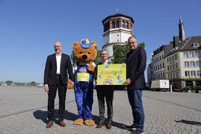Stellten das Konzept für den temporären Freizeitpark "Düsselland" vor (v.l.): Clemens Hauser, Messe Düsseldorf, das Düsselland-Maskottchen, OB Thomas Geisel und Schausteller Oscar Bruch. Foto: Ingo Lammert