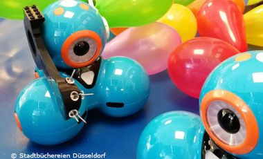 Zwei Dashbot Roboter und aufgeblasene Luftballons