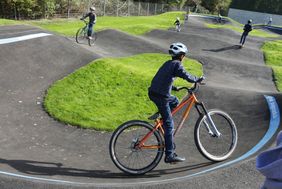 Der neue Pumptrack war sofort sehr begehrt bei den Kindern, die dort mit Rad oder Roller über die Strecke sausten; Foto: Lammert