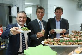 Tatkräftige Eröffnung (v.l.): OB Thomas Geisel, Eckhard Forst, Vorstandsvorsitzender der NRW.BANK, und Stadtdirektor Burkhard Hintzsche halfen in der neuen Mensa, die Schülerinnen und Schüler zu versorgen.
