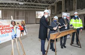 Oberbürgermeister Dr. Stephan Keller, Rita Becker, Schulleiterin des Cecilien-Gymnasiums, Stadtdirektor Burkhard Hintzsche und Michael Köhler, IPM, (v.l.) beim symbolischen Nagel-Einschlag. Foto: Melanie Zanin