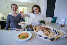 V.l.: Christiane Schmitz, Leiterin des Bürgerhaus Salzmannbau, und Sophia Ortulidu bei der Ausgabe der Neujahrssuppe an Verkäuferinnen und Verkäufer des Straßenmagazins "fifyfifty", © Landeshauptstadt Düsseldorf/Michael Gstettenbauer