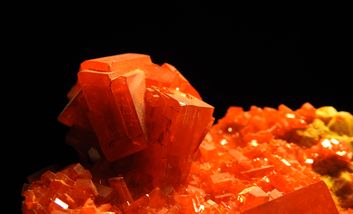 Das Bild zeigt ein leuchtend rotes Mineral.