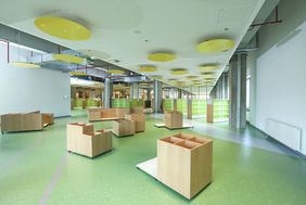 Für die Bilderbücher gibt es sogenannte Tröge (niedrige Möbel mit Öffnung nach oben) zum Blättern mit bequemen Sitzflächen dazwischen; Foto: Melanie Zanin