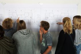 Richtfest Regenbogenschule: Das Kollegium studiert die Baupläne