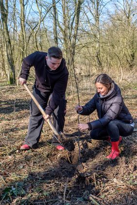 Mitarbeitende des Garten-, Friedhof- und Forstamtes und Auszubildenden der Stadtsparkasse Düsseldorf, darunter Lisa Jung und Paul Bruch, haben zum Abschluss der Pflanzaktion 100 Bäume gesetzt; Foto: Landeshauptstadt Düsseldorf/Uwe Schaffmeister