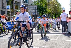 Foto von Kindern die am "Petit Départ" Kinderradrennen teilnehmen.