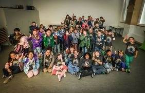 Verteilten die ersten von insgesamt 5.600 Blinkis für Erstklässler in der Regenbogenschule:  Beigeordneter Marcus Beyer (oben rechts)  und Christopher Hüls, stellvertretender Leiter der Regenbogenschule (oben links). Foto: Melanie Zanin