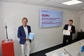 Stadtdirektor Burkhard Hintzsche (r.) und Prof. Dr. Theodor Stemper stellten das Buch mit zentralen Ergebnissen zum "Düsseldorfer Modell der Bewegungs-, Sport- und Talentförderung 2003 bis 2018", vor. Foto: Ingo Lammert