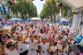 Foto der teilnehmenden Kinder, im Vordergrund die Gewinner die Ihre Pokale hoch halten 