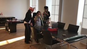 Mini-Möhnen-Sturm auf das OB-Büro: Mit der großen Schere geht es der Krawatte von Oberbürgermeister Dr. Stephan Keller an den Kragen. Der ist eigentlich gerade in einer WDR-Schalte.