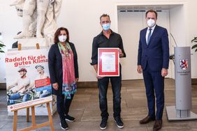 Ehrung Stadtradeln im Rathaus: Oberbürgermeister Dr. Stephan Keller und Umweltdezernentin Helga Stulgies überreichten Frank Strauß (Mitte) vom Familienteam "Grenzenlos unterwegs" eine Siegerurkunde. Foto: Melanie Zanin