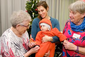 Auch der acht Monate alte Ilai freut sich über seine Söckchen: Mama Antje Coenen nutzte die Gelegenheit und kam mit den Seniorinnen Katharina Stöckelmayer (rechts) und Elisabeth Hecht ins Gespräch. Foto: Schaffmeister