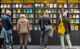 Reihe von Mesnchen vor Buchregalen