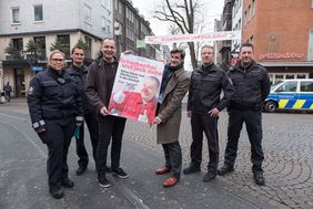 Die Aktion scherbenfreie Altstadt wird jetzt mit einem neuen Plakatmotiv beworben. Ordnungsdezernent Christian Zaum (3.v.r.) und Wagenbauer Jacques Tilly (3.v.l.) stellten das neue Motiv gemeinsam mit Mitarbeitern des OSD vor. Foto: Uwe Schaffmeister