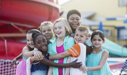 Mädchen mit Downsyndrom hat Spaß mit anderen Kindern, Foto: iStock, kali9