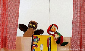 Zwei Handpuppen hinter einem Handpuppentheater