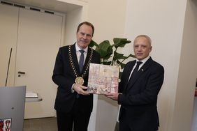 OB Dr. Stephan Keller überreicht Bürgermeister Roman Klitschuk als Geschenk ein Bild, in dem die Silhouetten von Düsseldorf und Czernowitz zu verschmelzen scheinen - Symbol der Partnerschaft.