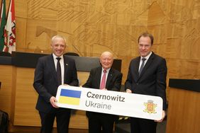 Herbert Rubinstein (Mitte) erhielt als Dank für seinen Einsatz für die Städtepartnerstadt ein Czernowitz-Städtepartnerschaftsschild.