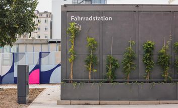 Begrünte Fassade der überdachten Fahrradabstellanlage Werhahn S; der Schriftzug „Fahrradstation“ befindet sich auf dem Gehäuse.