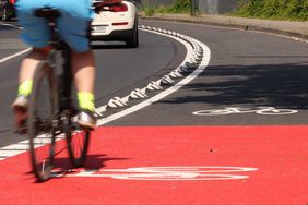 Neben dem Radweg wurden 20 Zentimeter breite Trennelemente auf der Fahrbahn angebracht, die den Radverkehr vom Autoverkehr abgrenzen. Foto: David Young