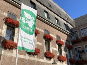 Vor dem Düsseldorfer Rathaus weht am heutigen Flaggentag, 8. Juli, wieder die Flagge des weltweiten Bündnisses der "Mayors for Peace". Foto: Landeshauptstadt Düsseldorf