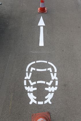 Maskenpiktogramm von oben. Die ergänzenden Pfeile dienen den Flaneuren als Hinweis, rechts zu gehen und Abstand zueinander zu halten. Foto: David Young