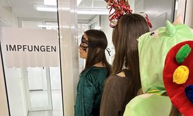 Kostümierte Personen, die für die Impfung anstehen © Gesundheitsamt Düsseldorf