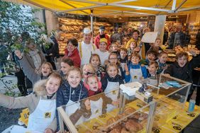 LandesBäckermeister Josef Hinkel mit der den Kindern der Maxschule am Verkaufsstand, Foto: Michael Gstettenbauer.hauptstadt Düsseldorf/Michael Gstettenbauer