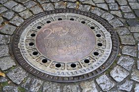 Ein kunstvoll gestalteter Kanaldeckel erinnert nahe dem Karnevalsmuseum an 200 Jahre Düsseldorfer Karneval – und verbindet städtische Infrastruktur mit rheinischer Lebensfreude. Foto: Landeshauptstadt Düsseldorf/Claus Langer