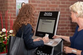 Mona Wolke vom Amt für Einwohnerwesen erläutert einer Studentin, welche Vorgänge an dem neuen Terminal erledigt werden können; Foto: ULB Düsseldorf/Agnes Lucas