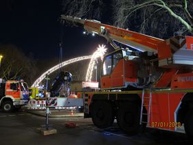Der Feuerwehrkran hebt das Auto aus dem Wasser.