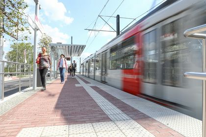 Bild von einem Bahnsteig mit U-Bahn und Passanten