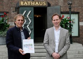 Jochen Kral, Dezernent für Mobilität der Landeshauptstadt Düsseldorf (links), und Florian Reeh, Leiter des Amtes für Verkehrsmanagement, mit dem Abschlussbericht Bürger*innendialog der U81/ 2. Bauabschnitt Rheinquerung; © Landeshauptstadt Düsseldorf/Wilfried Meyer